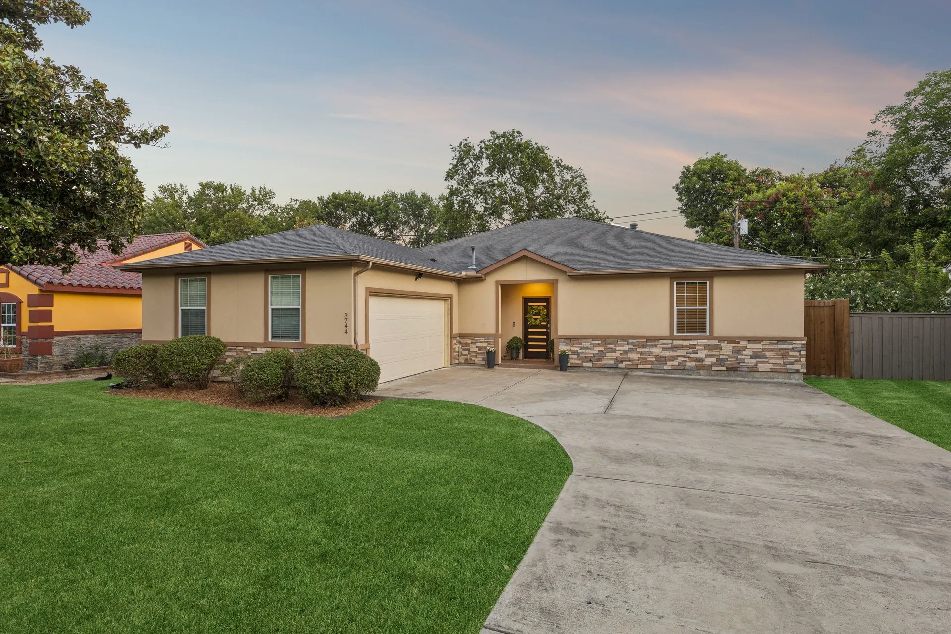 North Texas home exterior at twilight showing roofline, gutters, and grading